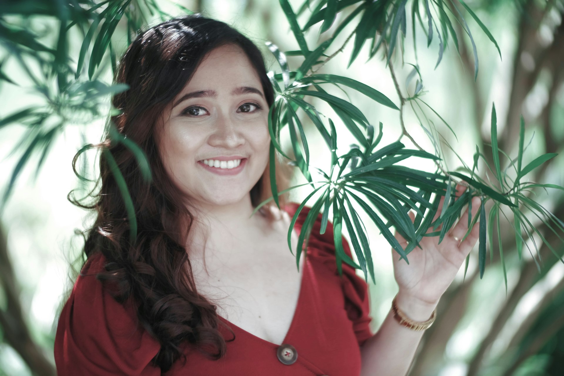 a woman in a red shirt is holding a plant
